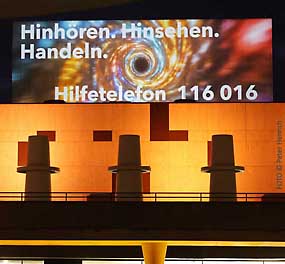Internationaler Tag gegen Gewalt an Frauen - am Staatstheater Darmstadt projeziert die Lichtinstallation die Hilfetelefonnummer an eine Wand ( Fotogalerie © Peter Henrich / HEN-FOTO ) Internationaler Tag gegen Gewalt an Frauen - am Staatstheater Darmstadt projeziert die Lichtinstallation die Hilfetelefonnummer an eine Wand ( Fotogalerie © Peter Henrich / HEN-FOTO )